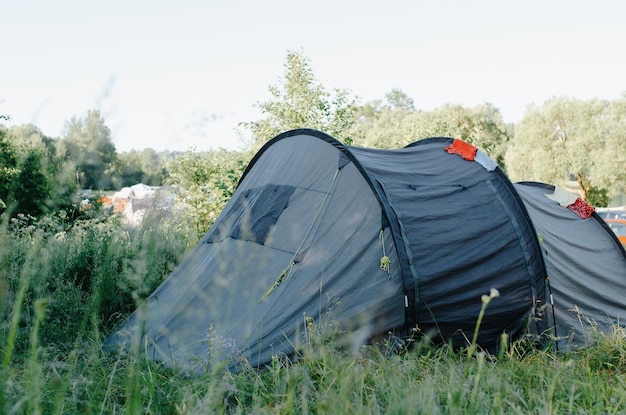 Camping trekking viajes naturaleza viaje concepto Gran tienda de campaña en el prado cerca del bosque en la mañana soleada