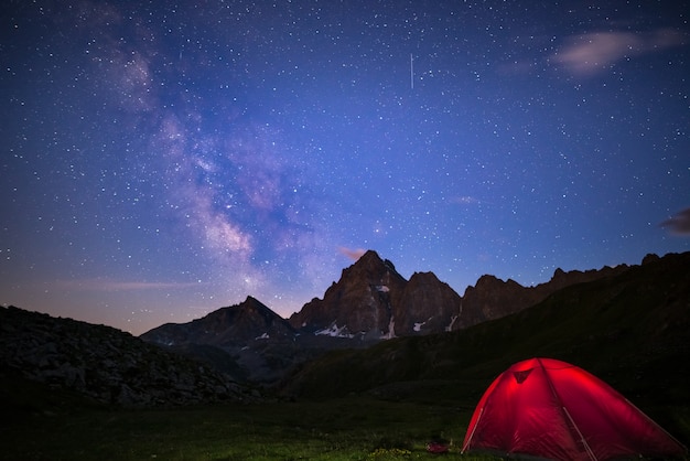 Camping unter Sternenhimmel und Milchstraße in großer Höhe auf den Alpen.