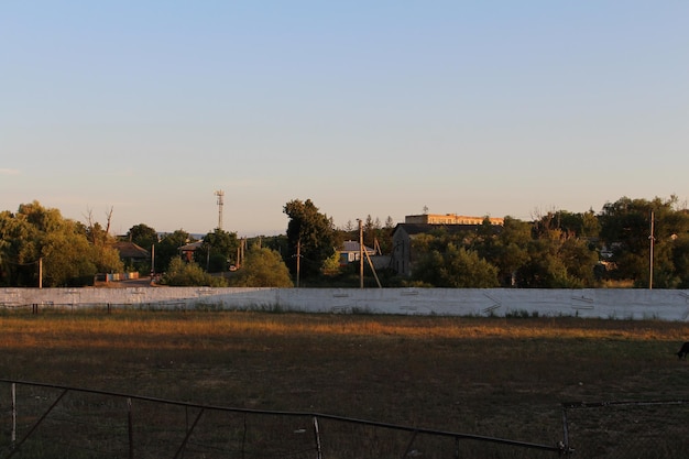 Un campo con árboles y edificios al fondo.