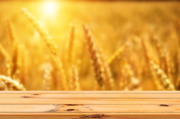 Foto campo de arroz listo para cosechar con mesa de madera, exhibición de productos