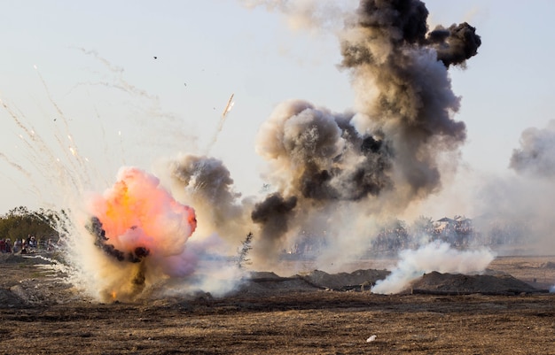 Foto el campo de batalla con explosiones de proyectiles y bombas, humo.