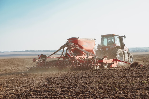 Campo de cultivo de trator. Agricultor em trator preparando a terra.