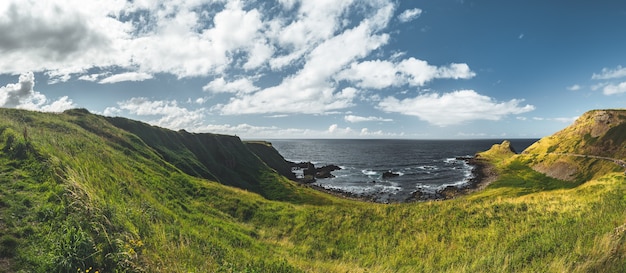 Campo de cultivo na costa de nothern, irlanda, antiga bela igreja rural com cemitério oceano