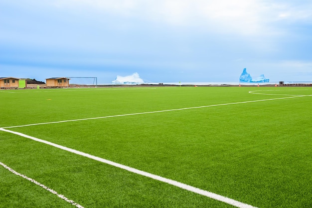 Campo de futebol com grama verde na costa do Oceano Atlântico em Qeqertarsuaq, oeste da Groenlândia