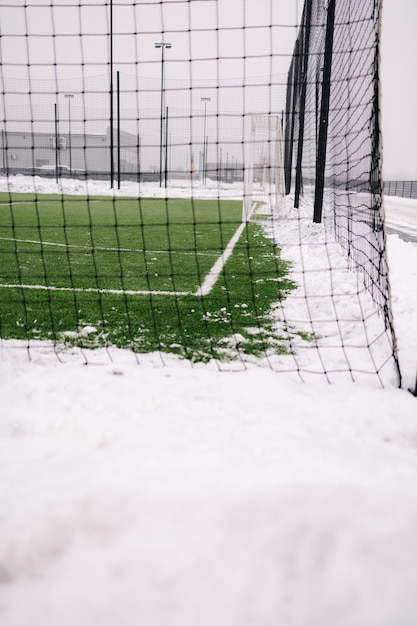 Campo de futebol é limpo de neve no inverno