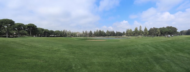 campo de golfe com floresta e lagoa