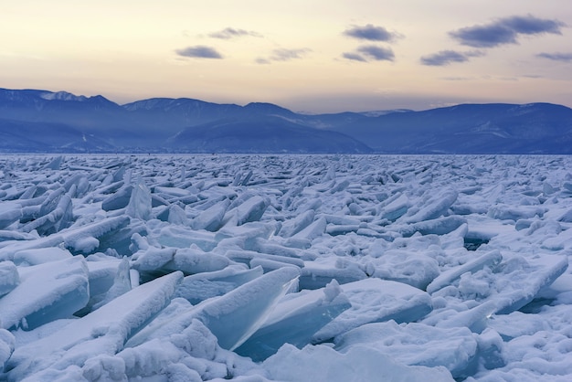Campo de hummock sem fim no Lago Baikal congelado. Pilhas de escombros cobertos de neve de gelo azul em um dia gelado. Fundo natural frio. Paisagem incomum de inverno