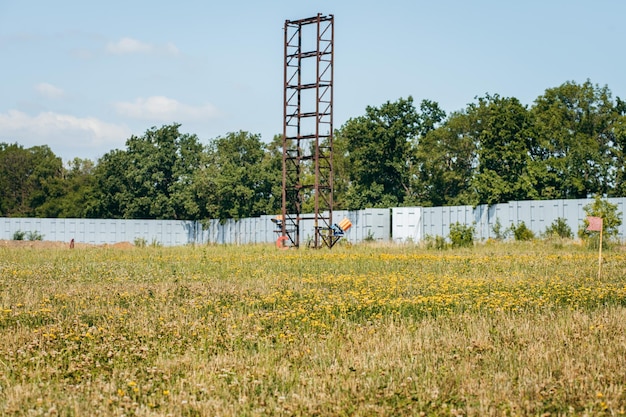 Campo de entrenamiento de escopeta vacío con hierba verde y máquinas de plat