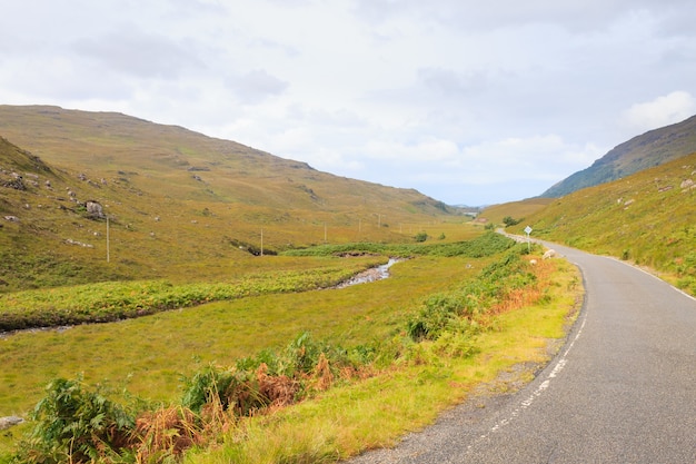 Campo escocés del canal del camino. Camino en perspectiva. Panorama de Escocia