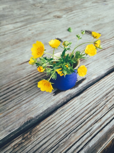 Campo de flores amarillas en florero azul