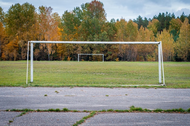 Campo de fútbol Césped verde y cinta de correr de asfalto agrietado Complejo deportivo abandonado