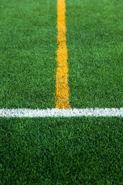 Campo de fútbol de fútbol de césped artificial verde con límite de línea blanca y amarilla