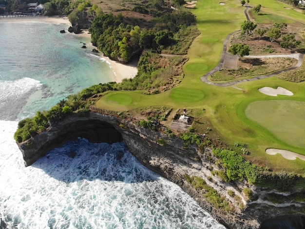 Foto campo de golf de lujo con vista aérea junto al océano y la playa del acantilado en la isla de bali, indonesia