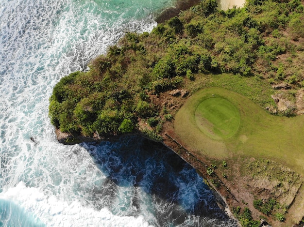 Campo de golf de lujo con vista aérea junto al océano y la playa del acantilado en la isla de Bali, Indonesia