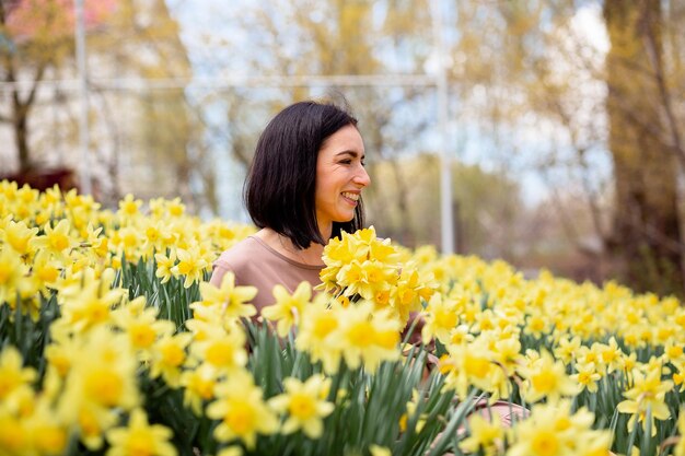 El campo de Narciso La chica sostiene un gran ramo fragante de flores amarillas