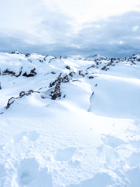 Campo de nieve con montañas blancas bajo un cielo nublado en Islandia