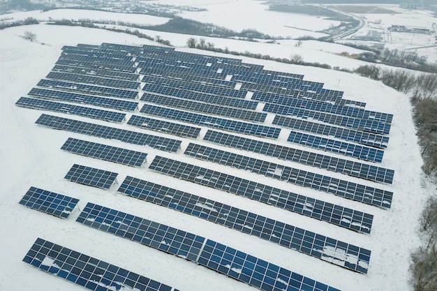 Campo de paneles solares con nieve en paneles