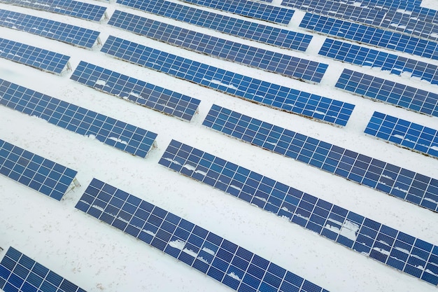 Campo de paneles solares con nieve en paneles