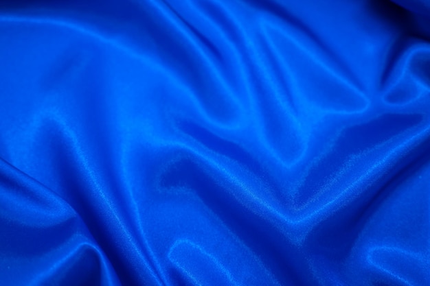 Campo têxtil de tecido de seda de cetim azul abstrato com fundo de dobras onduladas de vinco