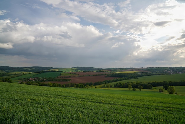 Campos com grama verde Céu azul com muitas nuvens Paisagem rural Área montanhosa Árvores