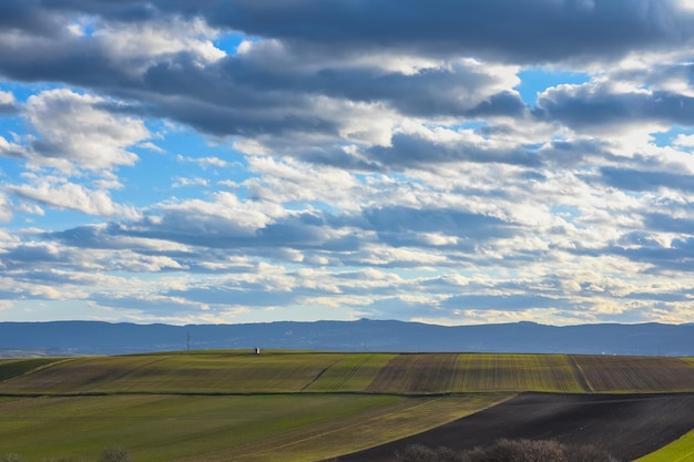 Campos diferentes coloridos com nuvens maravilhosas no céu azul