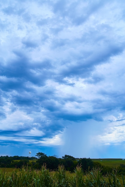 Campos de maíz y torre de agua en oscuras nubes ominosas