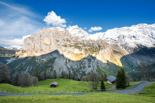Campos verdes y famosa ciudad turística impresionante con altos acantilados en Lauterbrunnen, Suiza