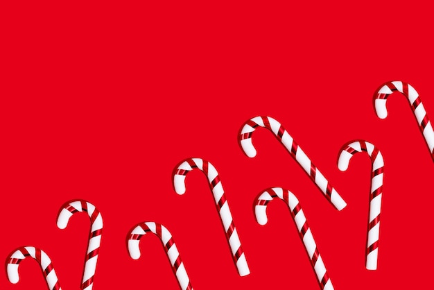 Foto caña de caramelo de navidad sobre un fondo rojo espacio de copia de vista superior plano y minimalista creativo de navidad
