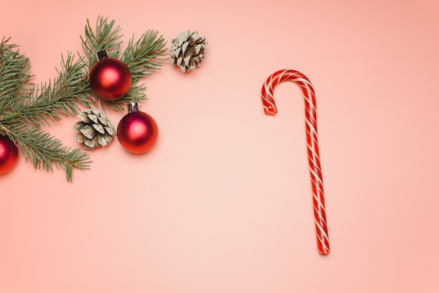 Foto caña de caramelo y rama de árbol de navidad con juguetes y piñas