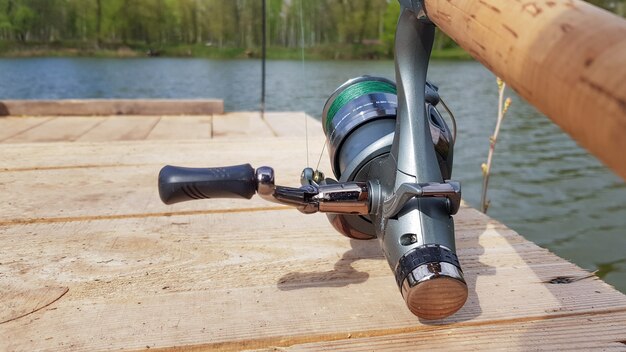 Caña de pescar carpa aislada en el lago y puente de madera