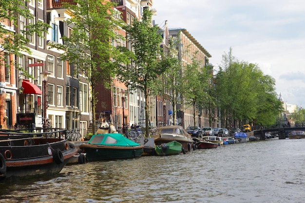 Canais de Amsterdã e casas típicas com céu claro de primavera