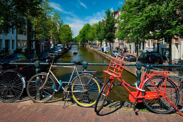 Canal de Amsterdam con barcos y bicicletas en un puente