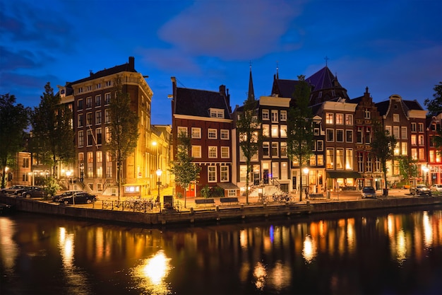 Canal de amterdam, puente y casas medievales en la noche