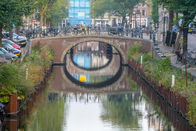 Canal en el centro de Ámsterdam y vehículos estacionados