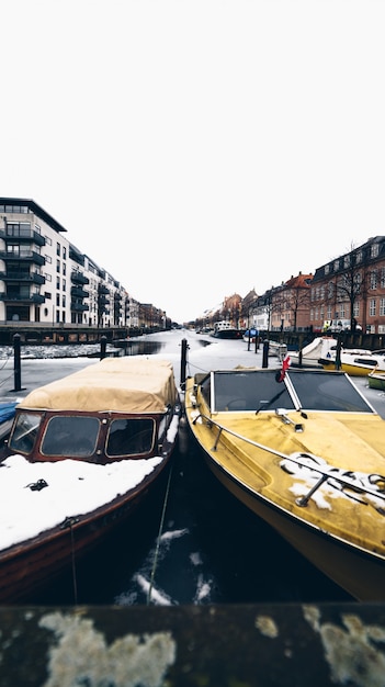 Canal congelado con edificios y barcos en Copenhague