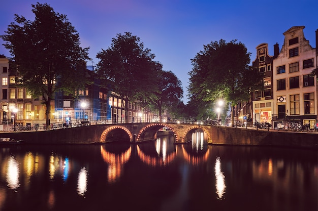 Canal de Amesterdão, ponte e casas medievais à noite