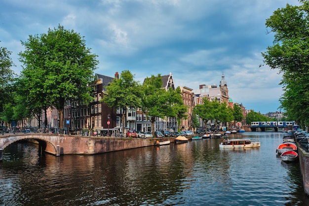 Canal de amsterdã com ponte e casas antigas