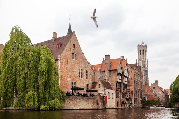 Canal em Bruges com a famosa torre Belfry na superfície. Bélgica