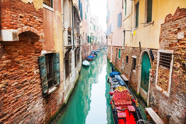 Canal escénico con edificios antiguos y góndola en Venecia, Italia.