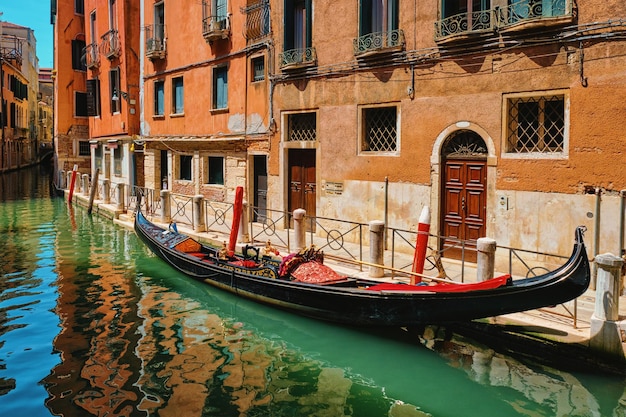 Canal estrecho con góndola en venecia italia