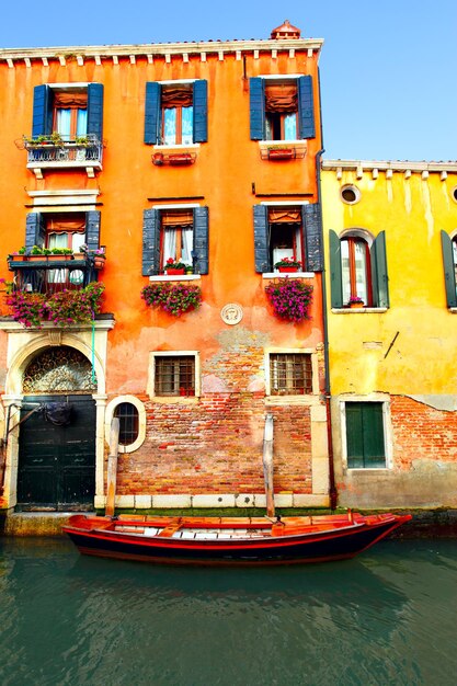 Canal estreito com barco em Veneza, Itália