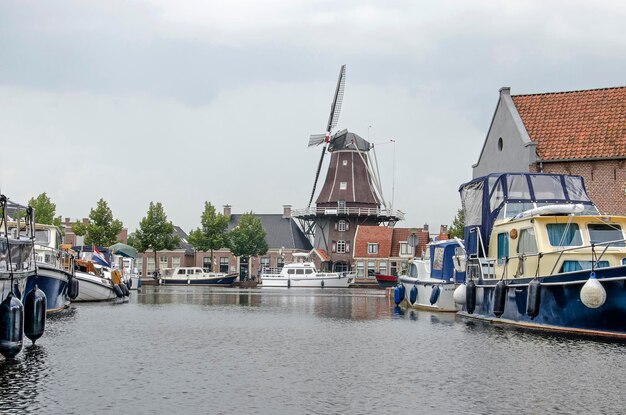 Foto canal holandés con yates y molino de viento