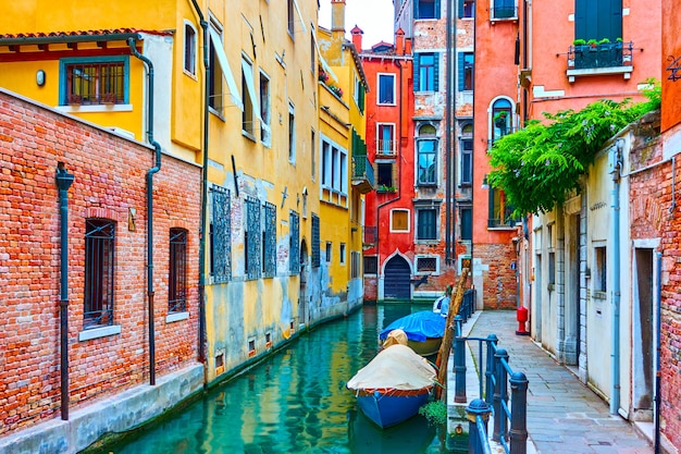 Canal lateral estreito com barcos a motor atracados em Veneza, Itália