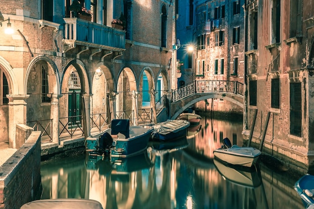 Canal lateral nocturno y puente en Venecia Italia