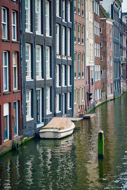 Canal de Ámsterdam Damrak con casas Países Bajos