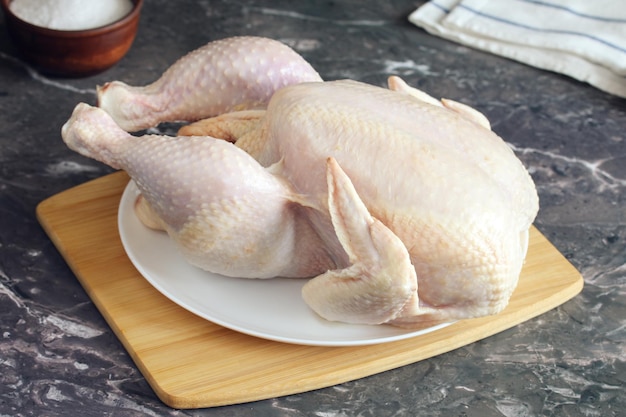 Canal de pollo en una tabla de cortar carne de ave cruda