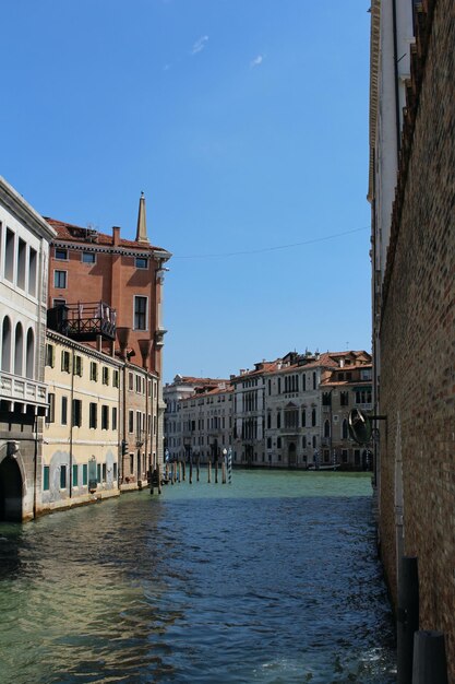 Un canal en Venecia con un cielo azul.