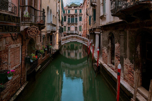 Un canal en Venecia con un puente y un puente al fondo.