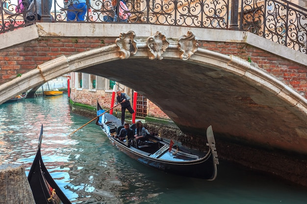 Foto canal veneciano con góndolas y casas históricas.