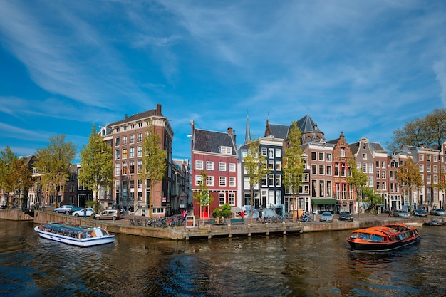 Canal de vista de Amsterdam con puente boad y casas antiguas